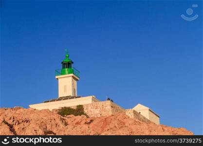 The lighthouse at Ile Rousse in the Balagne region of Corsica against a deep blue sky
