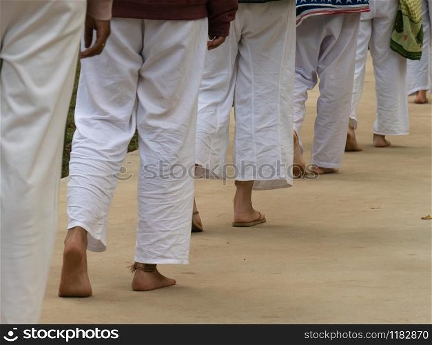 The line of people feet walking meditation and all in white clothes.