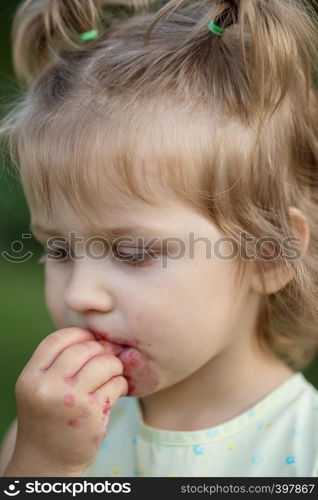 the little girl eats cherry in the garden. Summer