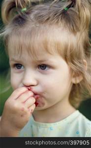 the little girl eats cherry in the garden. Summer