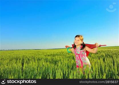 The little girl on a field with an umbrella
