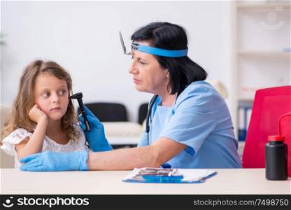 The little girl visiting old female doctor. Little girl visiting old female doctor