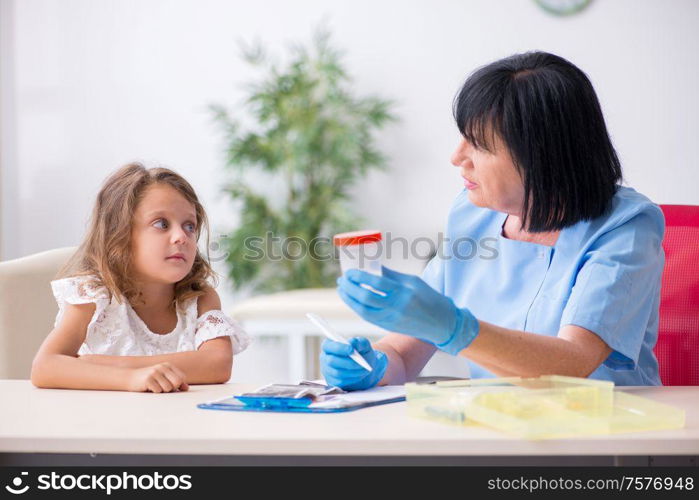 The little girl visiting old female doctor. Little girl visiting old female doctor