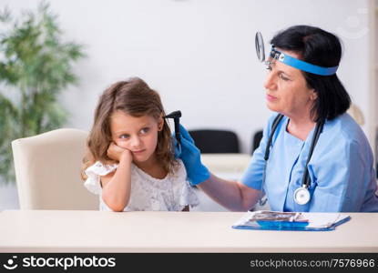 The little girl visiting old female doctor. Little girl visiting old female doctor