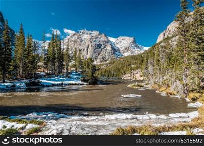 The Loch Lake with rocks and mountains in snow around at autumn. Rocky Mountain National Park in Colorado, USA.