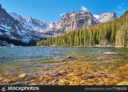 The Loch Lake with rocks and mountains in snow around at autumn. Rocky Mountain National Park in Colorado, USA. 