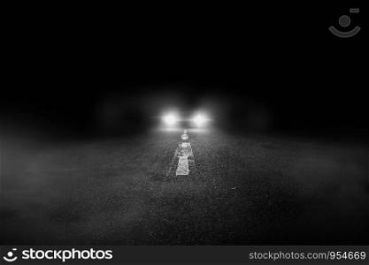 The lonely road at night with the car running.