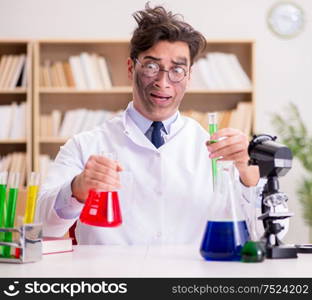 The mad crazy scientist doctor doing experiments in a laboratory. Mad crazy scientist doctor doing experiments in a laboratory