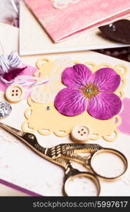 The making scrapbooking album with rings and decorations on the table and tools. The making postcard