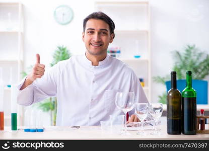 The male chemist examining wine samples at lab. Male chemist examining wine samples at lab