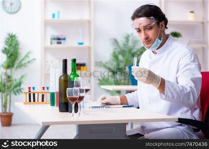 The male chemist examining wine samples at lab. Male chemist examining wine samples at lab
