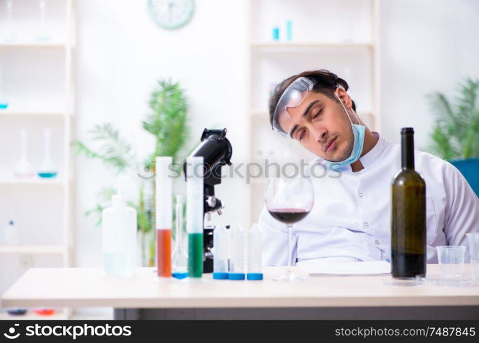 The male chemist examining wine samples at lab. Male chemist examining wine samples at lab