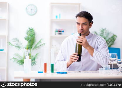 The male chemist examining wine samples at lab. Male chemist examining wine samples at lab