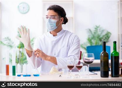 The male chemist examining wine samples at lab. Male chemist examining wine samples at lab