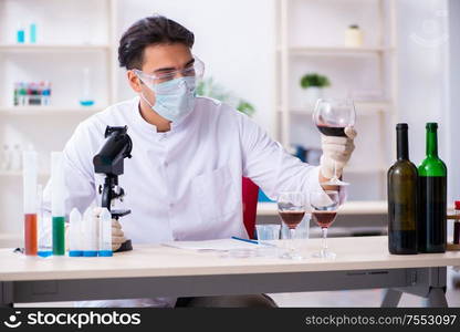 The male chemist examining wine samples at lab. Male chemist examining wine samples at lab