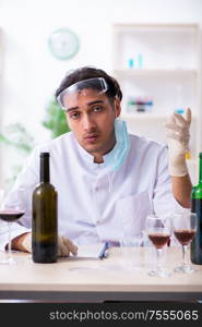 The male chemist examining wine samples at lab. Male chemist examining wine samples at lab