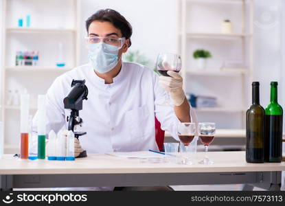 The male chemist examining wine samples at lab. Male chemist examining wine samples at lab