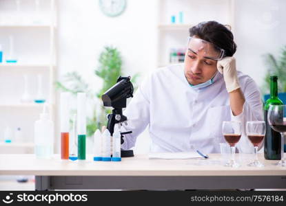 The male chemist examining wine samples at lab. Male chemist examining wine samples at lab