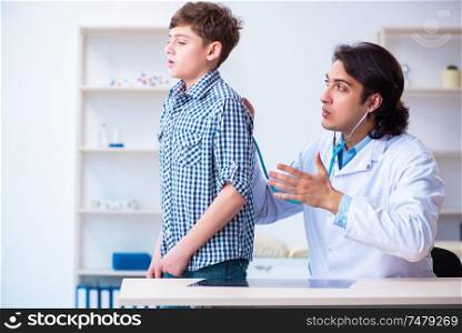 The male doctor examining boy by stethoscope . Male doctor examining boy by stethoscope