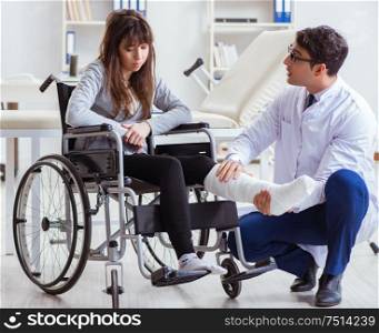 The male doctor examining female patient on wheelchair. Male doctor examining female patient on wheelchair