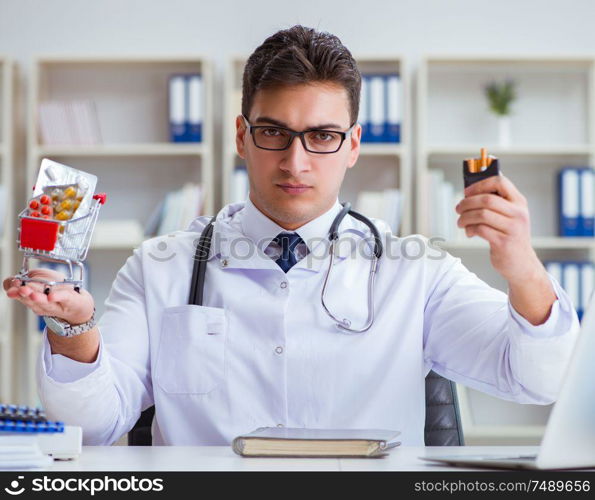 The male doctor in anti-smoking conceptwithcigarette pack. Male doctor in anti-smoking conceptwithcigarette pack