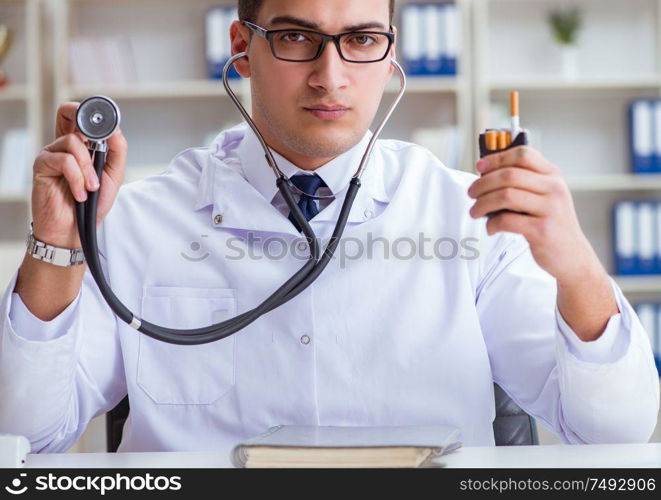 The male doctor in anti-smoking conceptwithcigarette pack. Male doctor in anti-smoking conceptwithcigarette pack