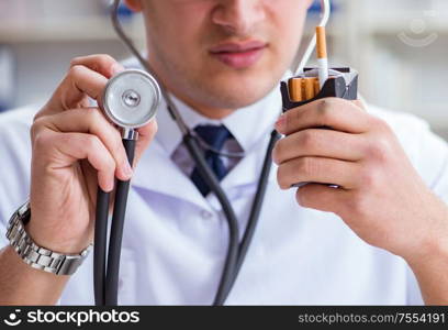 The male doctor in anti-smoking conceptwithcigarette pack. Male doctor in anti-smoking conceptwithcigarette pack