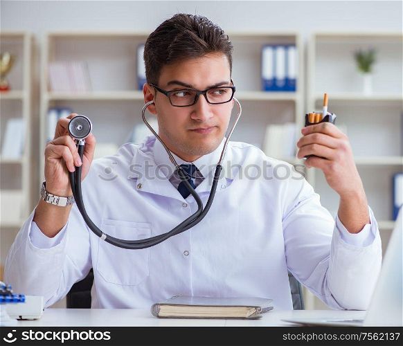 The male doctor in anti-smoking conceptwithcigarette pack. Male doctor in anti-smoking conceptwithcigarette pack