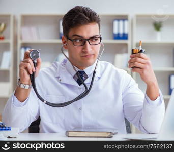 The male doctor in anti-smoking conceptwithcigarette pack. Male doctor in anti-smoking conceptwithcigarette pack