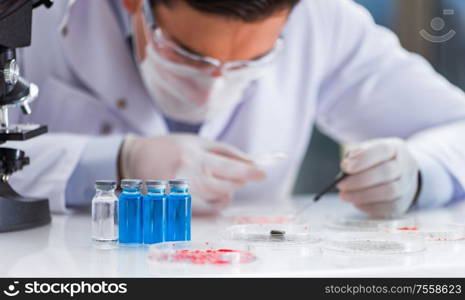 The male doctor working in the lab on virus vaccine. Male doctor working in the lab on virus vaccine