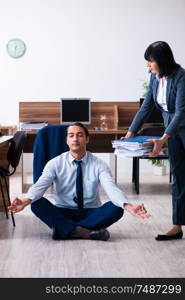 The male employee doing yoga exercises in the office. Male employee doing yoga exercises in the office