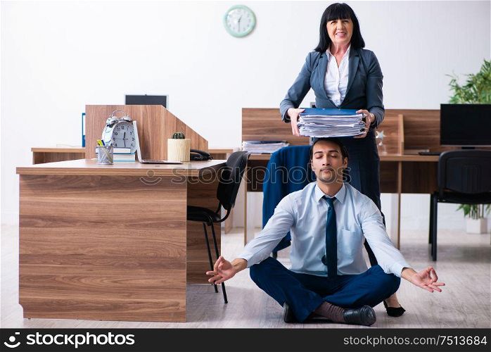 The male employee doing yoga exercises in the office. Male employee doing yoga exercises in the office