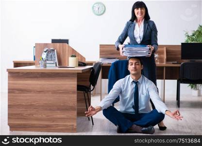 The male employee doing yoga exercises in the office. Male employee doing yoga exercises in the office