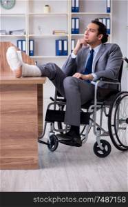 The male employee in wheel-chair in the office . Male employee in wheel-chair in the office