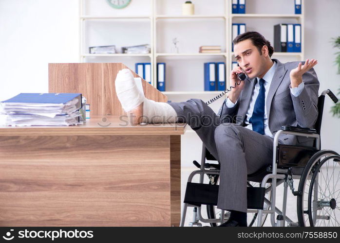 The male employee in wheel-chair in the office. Male employee in wheel-chair in the office