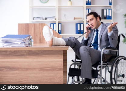 The male employee in wheel-chair in the office. Male employee in wheel-chair in the office