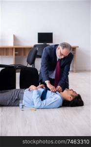 The male employee suffering from heart attack in the office . Male employee suffering from heart attack in the office 