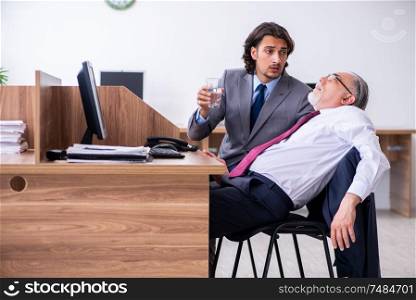 The male employee suffering from heart attack in the office . Male employee suffering from heart attack in the office