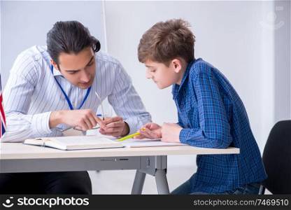The male english teacher and boy in the classroom . Male english teacher and boy in the classroom 