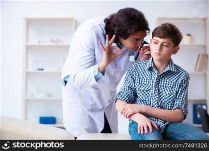 The male otolaryngologist examining boy&rsquo;s ear. Male otolaryngologist examining boy&rsquo;s ear