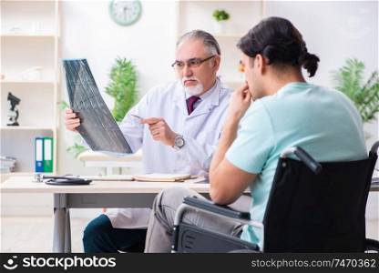The male patient in wheel-chair visiting old doctor . Male patient in wheel-chair visiting old doctor 