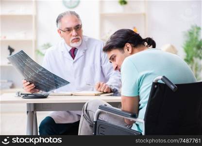 The male patient in wheel-chair visiting old doctor . Male patient in wheel-chair visiting old doctor