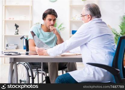 The male patient in wheel-chair visiting old doctor . Male patient in wheel-chair visiting old doctor