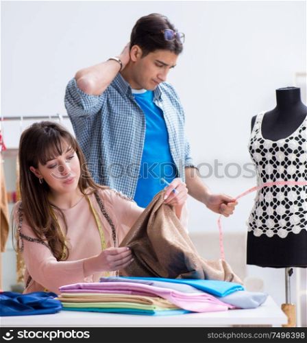 The male tailor with female student in workshop. Male tailor with female student in workshop