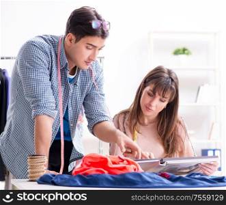 The male tailor with female student in workshop. Male tailor with female student in workshop