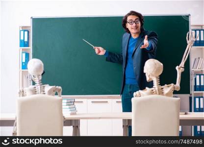 The male teacher and skeleton student in the classroom . Male teacher and skeleton student in the classroom
