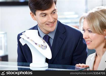 The man and the woman choose a gift in jeweller shop