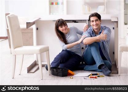 The man and woman assembling furniture at home. Man and woman assembling furniture at home