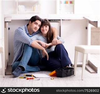 The man and woman assembling furniture at home. Man and woman assembling furniture at home