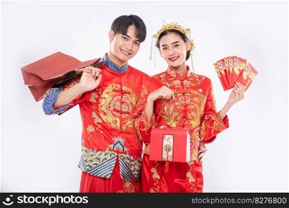 The Man and woman wear cheongsam get the red bag , gift money and some gift from their relative in traditional day